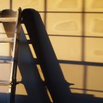 A metal ladder casting a shadow on a wall, illustrating a home improvement theme