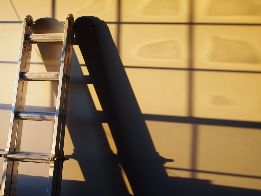 A metal ladder casting a shadow on a wall, illustrating a home improvement theme